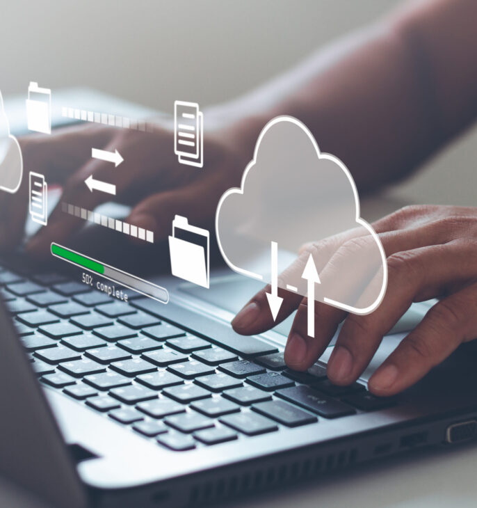 Utilisateur travaillant sur un ordinateur portable avec des ic&ocirc;nes de stockage cloud et de transfert de fichiers.