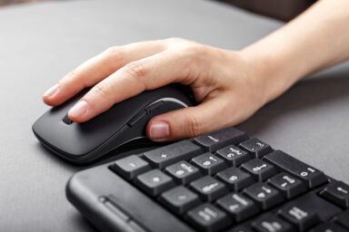 une main sur une souris d'ordinateur avec un clavier
