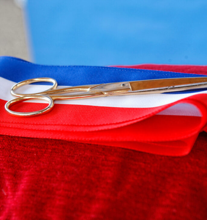 ruban pour inaugration bleu blanc rouge poser sur un cousin avec des ciseaux or