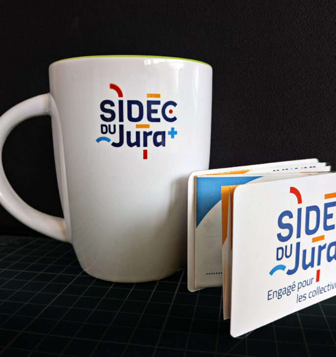 tasse avec le logo du sidec et vademecum pos&eacute; devant