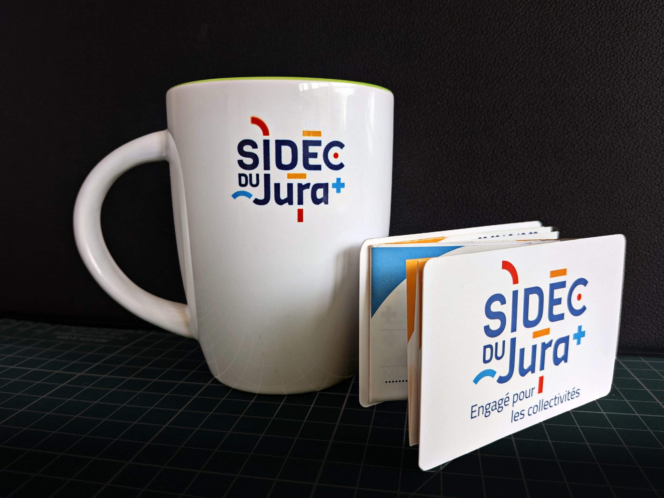 tasse avec le logo du sidec et vademecum pos&eacute; devant