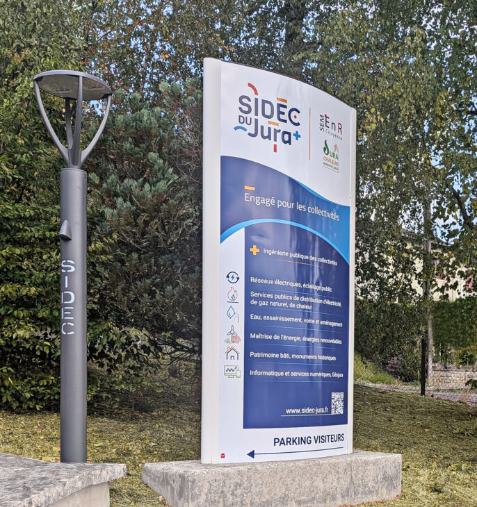 panneau d'accueil &agrave; l'entr&eacute;e du SIDEC avec un lampadaire led dans lequel sont grav&eacute; les lettres SIDEC.